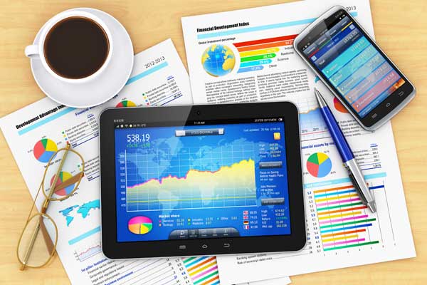 tablet computer on top of business papers with graphs that represent marketing strategy and marketing planning