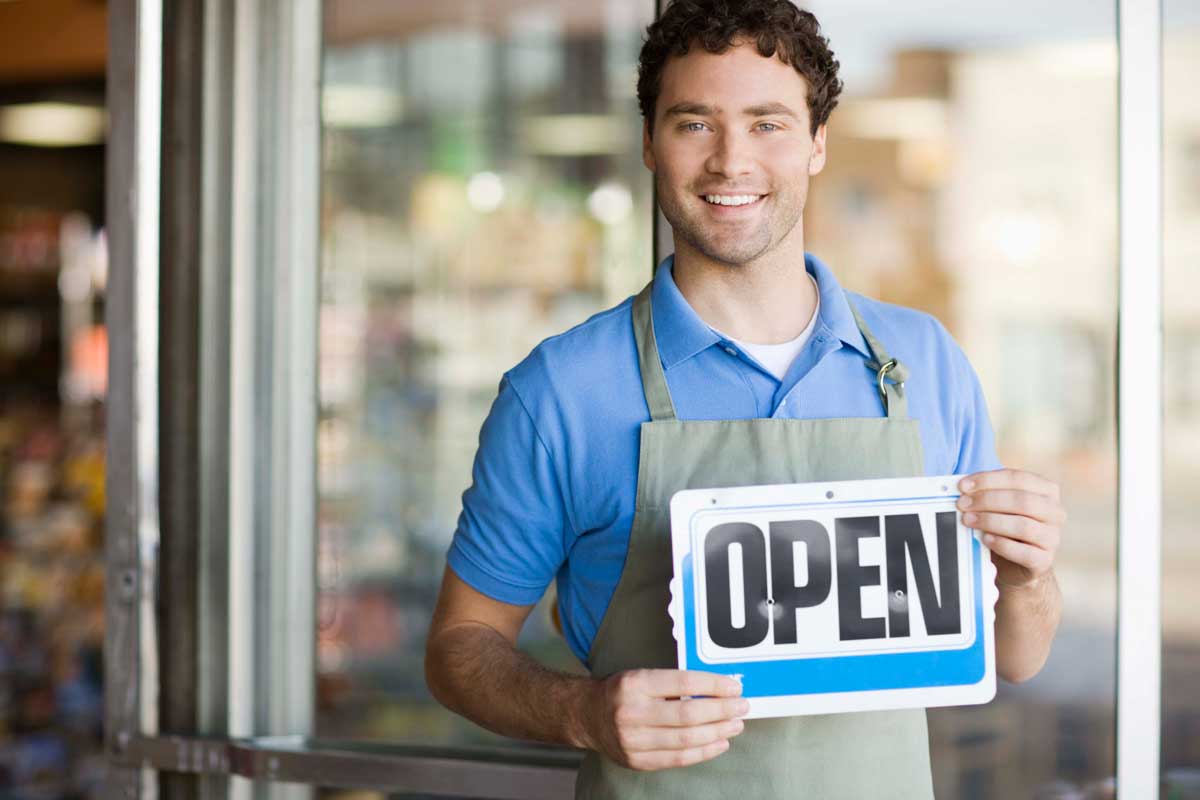 small business marketing services are geared towards small business shop owners like this one holding an open sign