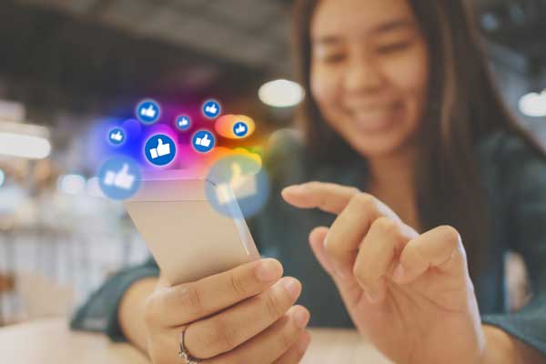 a woman using a mobile device with icons representing social media marketing