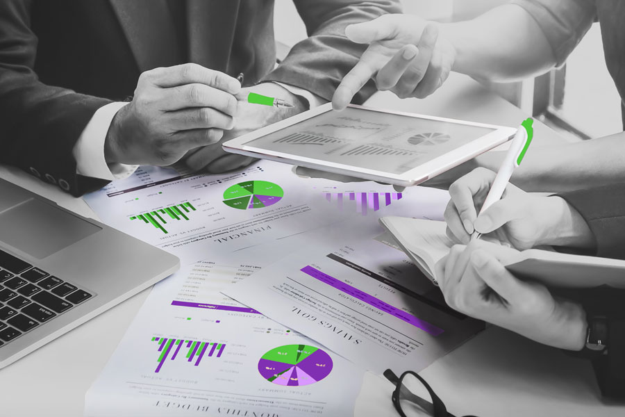 consultants with a tablet computer and printouts of graphs, representing marketing consulting services