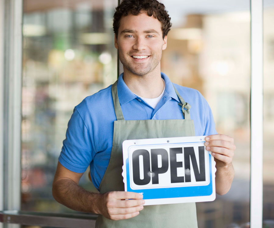 small business marketing services are geared towards small business shop owners like this one holding an open sign